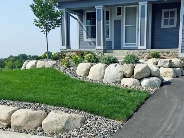 Professional landscape installation with boulder border and front yard design