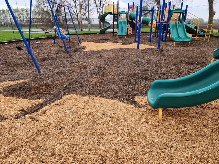 Fresh wood chip mulch installation at commercial playground