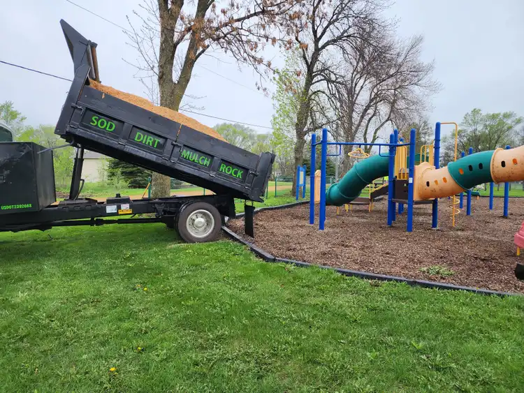 Ristau dump trailer unloading mulch at commercial playground