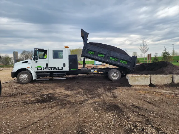 Ristau dump truck delivering topsoil and fill dirt on job site