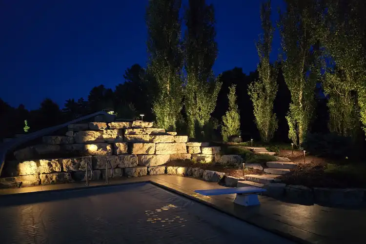 Illuminated boulder retaining wall terraces and landscape lighting at night