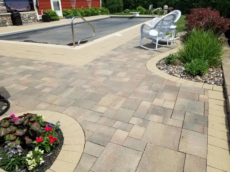 Finished paver patio and pool surround installation by Ristau Property Maintenance