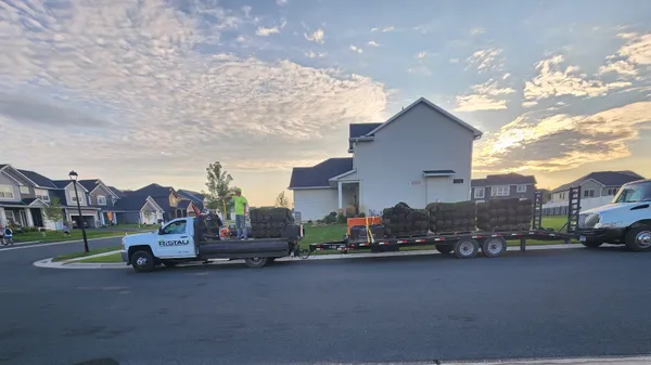 Ristau truck and trailer with skid steer loaded for residential job at dawn